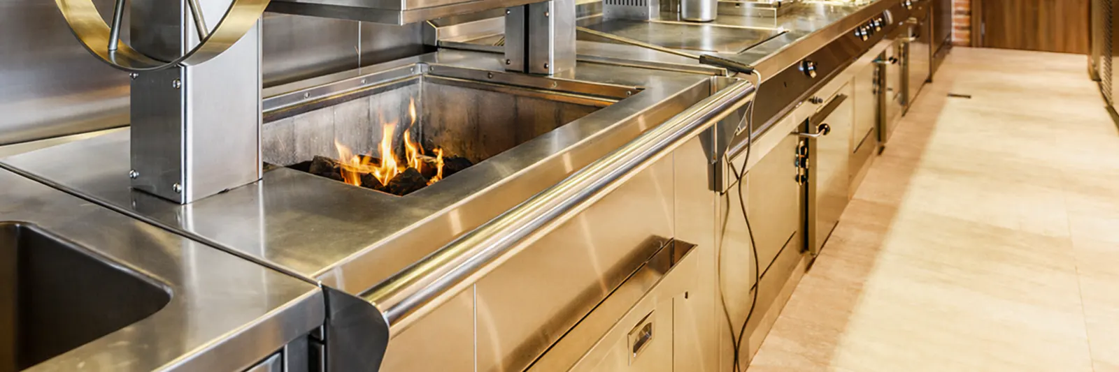 Live charcoal grill on the brass-trimmed cooking line at The St. Regis Downtown Dubai